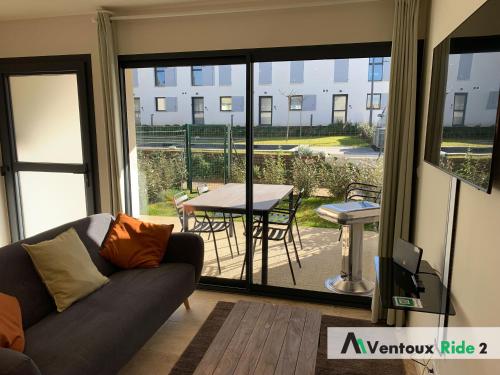 a living room with a couch and a view of a patio at Ventoux Ride in Malaucène