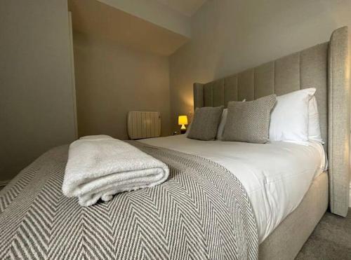 a bedroom with a bed with a white blanket on it at Superior Stay, Sophia Gardens, City Centre and Stadium Sleeps 4 in Cardiff