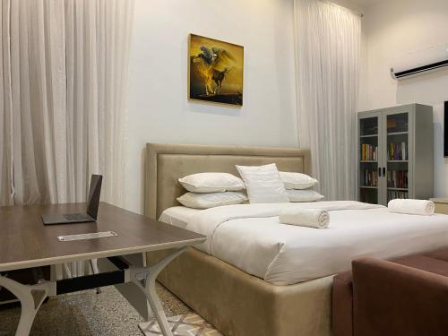 a hotel room with two beds and a desk with a laptop at Maestro in Lagos