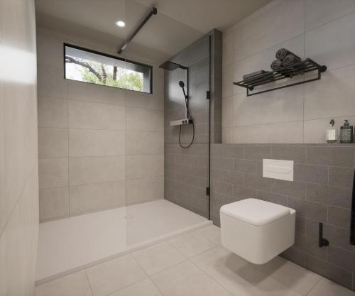 a bathroom with a shower and a toilet and a window at Maestro in Lagos