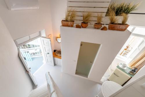 una pequeña cocina blanca con plantas en un estante en MYKONOS VIBES TOWN LOFT, en Mykonos ciudad