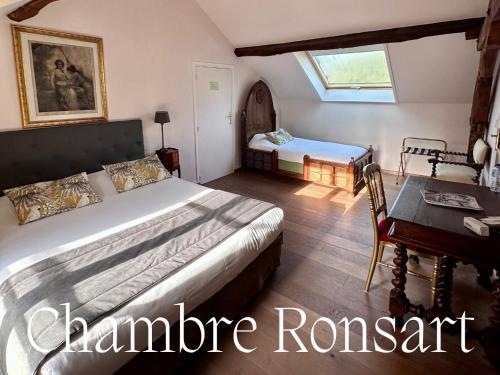 a bedroom with a bed and a table and a desk at Domaine de la Butte Ronde in La Boissière-École