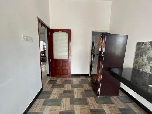 a kitchen with a refrigerator and a floor at kadal veedu in Varkala