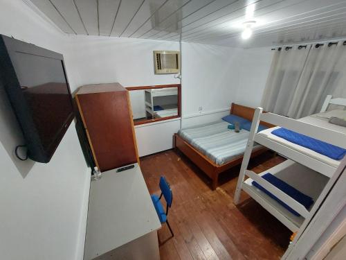 a small room with two bunk beds and a refrigerator at Pousada Rancho 60 in Balneário Camboriú