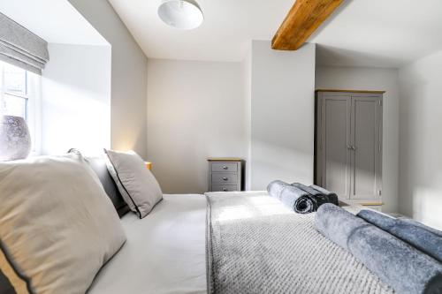 a bedroom with a white bed with a camera on it at The Old Warehouse Ely "Apartments" in Ely