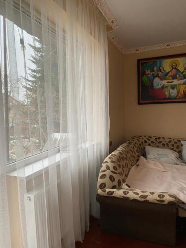 - une chambre avec un lit et une fenêtre avec des rideaux dans l'établissement Apartment Bograch, à Moukatcheve
