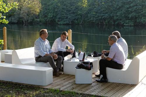 a group of men sitting around a table on a deck at Hotel du Lac Foix in Foix