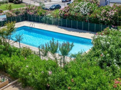 - une vue sur la piscine avec des plantes dans l'établissement Superbe 3P avec grande terrasse, piscine, proche plage et commerces au Grau-du-Roi - FR-1-307-137, au Grau-du-Roi