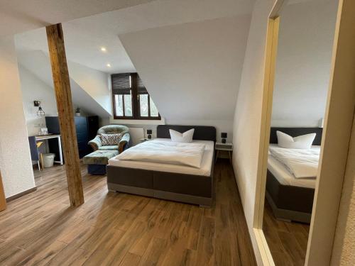 1 Schlafzimmer mit 2 Betten und einem Stuhl in der Unterkunft Avenue Das Gästehaus in Chemnitz