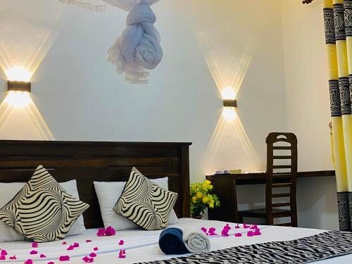 een slaapkamer met een bed met roze bloemen erop bij Lucky Villa Sigiriya in Sigiriya
