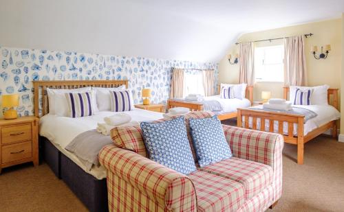 a bedroom with a bed and a couch in it at The Bell Inn in Walberswick