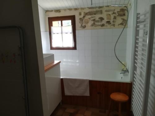 a bathroom with a bath tub and a window at Gite un toit sur la Doa in Apt