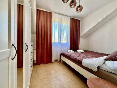 Apartament Wisteria في برزيميسل: غرفة نوم بسرير مع ستائر حمراء ونافذة