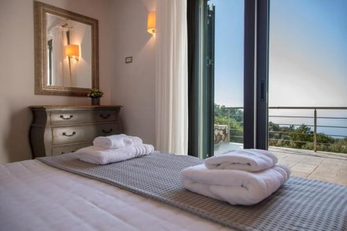 塞沃塔的住宿－Villa Aldena Luxury Residence，卧室配有窗户,床上配有2条毛巾