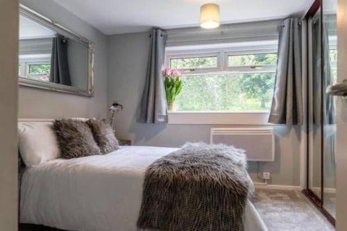 Schlafzimmer mit einem Bett und einem Fenster in der Unterkunft Cosy 1 Bed with Parking in City Centre in Glasgow