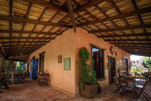 un patio con tavoli, sedie e soffitto in legno di Tiô Isolda Artes & Hospedaria a Casa Branca