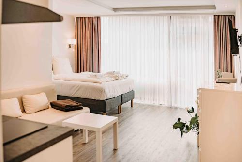 une chambre d'hôtel avec un lit et un canapé dans l'établissement Haus Vier Jahreszeiten am See HS 939, à Hahnenklee