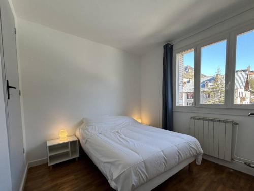 une chambre blanche avec un lit et une fenêtre dans l'établissement Appartement 3 pièces lumineux à Briançon avec parking - FR-1-330C-141, à Briançon