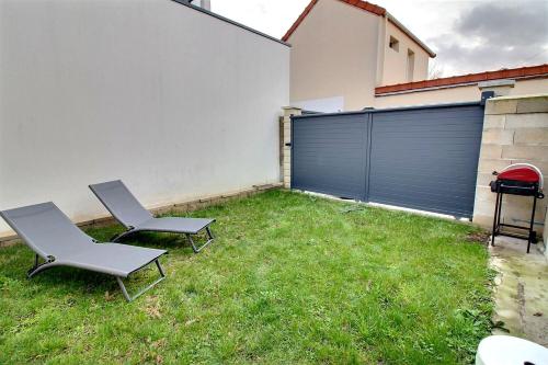 - une cour avec 2 chaises et une porte de garage dans l'établissement Havre de paix, à Villejuif