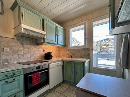 une cuisine avec des armoires vertes et une cuisinière four supérieur dans l'établissement Appartement 3 pièces lumineux à Briançon avec parking - FR-1-330C-141, à Briançon