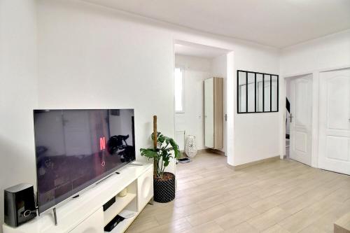 un salon avec une grande télévision à écran plat dans l'établissement Havre de paix, à Villejuif