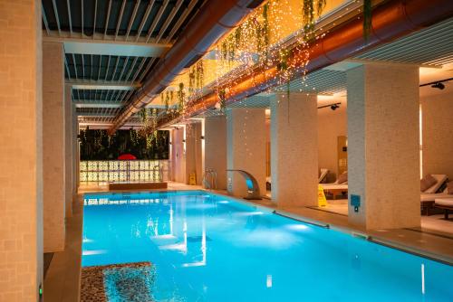 a large swimming pool with blue water in a building at Lucky Bansko Aparthotel SPA & Relax in Bansko