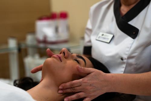 a woman getting her hair washed at a salon at Lucky Bansko Aparthotel SPA & Relax in Bansko
