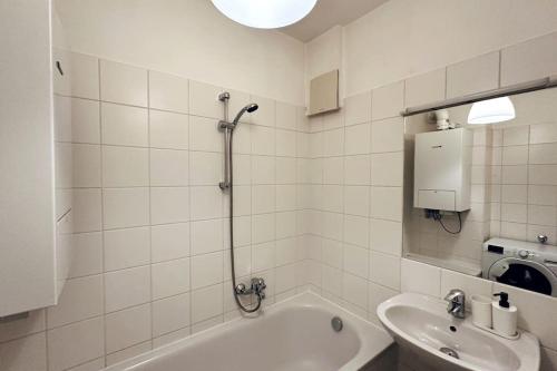 a bathroom with a bath tub and a sink at Cosy & New Urban Apartment in Green Hood in Vienna