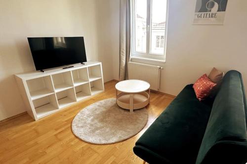 a living room with a couch and a tv at Cosy & New Urban Apartment in Green Hood in Vienna