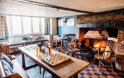 a living room with a table and a fireplace at The Bell Inn in Walberswick