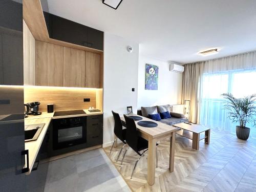 a kitchen and living room with a table and a couch at Panorama Zamkowe 5 in Rzeszów