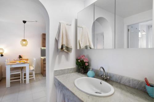 a white bathroom with a sink and a table at Views of Sunsets in Taurito