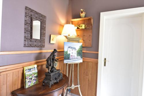a room with a table with a lamp and a picture at Hotel Le Luxembourg in La Roche-en-Ardenne