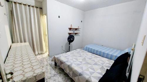 um quarto com uma cama e uma ventoinha. em Will's House em São Luís