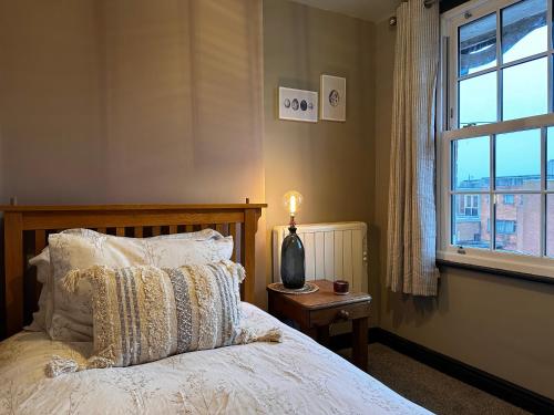 1 dormitorio con 1 cama con lámpara y ventana en The Hideaway en Stratford-upon-Avon