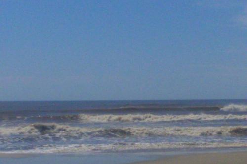 una playa con olas en el océano en un día claro en casa maravilhosa a Beira-Mar da Salinas, en Cidreira