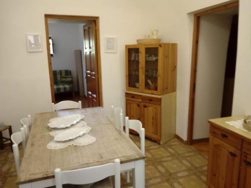 kuchnia z drewnianym stołem z białymi krzesłami w obiekcie VILLA NONNA NINA w mieście Locorotondo