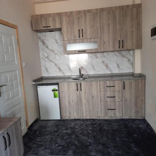 an empty kitchen with wooden cabinets and a sink at Yeşilgöl doğa evleri in Tokat