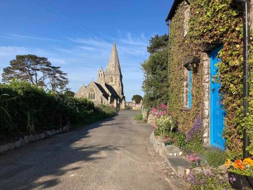 an empty street with a church in the background at Tan Y Bryn in Llanrhystyd