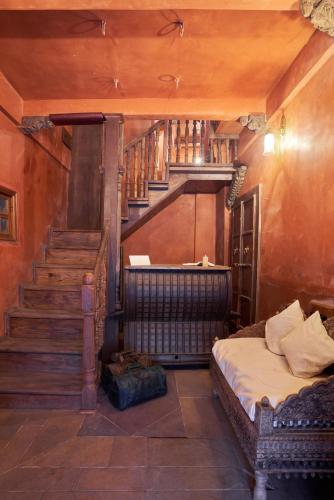 a bedroom with a bed and a stair case at Kaladwas Lal Haveli - A Heritage Boutique Hotel in Udaipur
