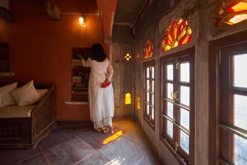 a woman in a white dress looking in a mirror at Kaladwas Lal Haveli - A Heritage Boutique Hotel in Udaipur