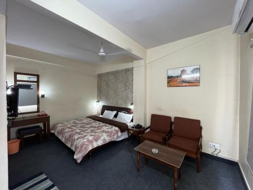 a hotel room with a bed and a television at Gautam Hotel in Varanasi