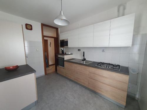 a kitchen with white cabinets and a black counter top at Appartamento Valle dei Laghi in Calavino