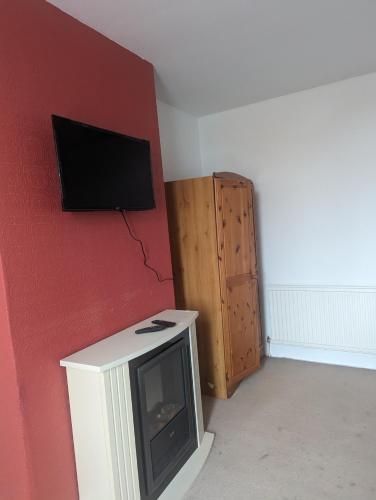 a living room with a tv on a red wall at Little Guesthouse in Cleveleys