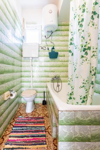 a bathroom with a tub and a toilet at Seaview Holiday Apartments in Slatine