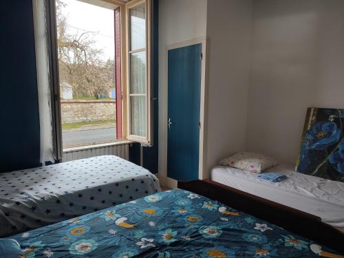 une chambre avec deux lits et une fenêtre dans l'établissement Maison à 3 chambres, rustique, fraîche, entretenue, 15' zoo beauval commerces pharmacie route médiane, à Luçay-le-Mâle