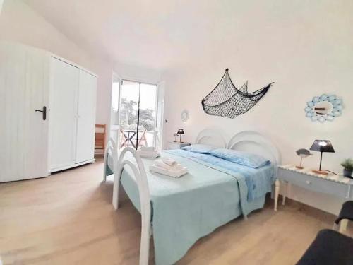 - une chambre avec un lit, une table et une fenêtre dans l'établissement Villa i Ginepri. A pochi passi dal mare., à Marina di Sorso