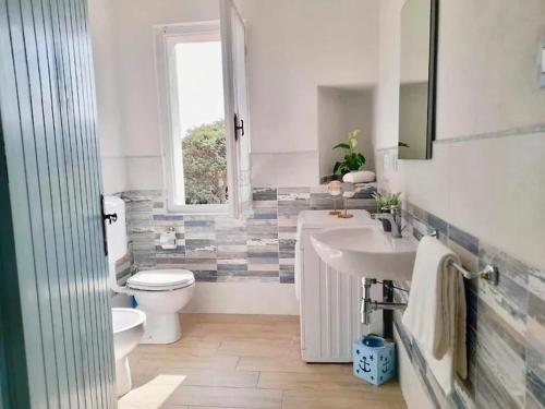 La salle de bains est pourvue d'un lavabo, de toilettes et d'une fenêtre. dans l'établissement Villa i Ginepri. A pochi passi dal mare., à Marina di Sorso
