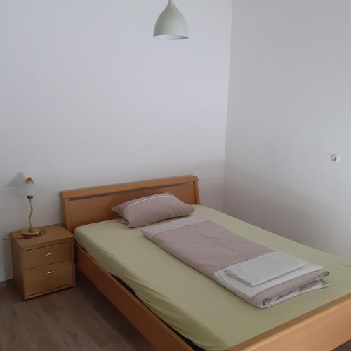 a small bedroom with a bed and a night stand at Backstubencafe Beck in Ansbach