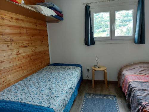 sypialnia z 2 łóżkami i oknem w obiekcie La petite maison Gîte 2 étoiles w mieście La Bresse